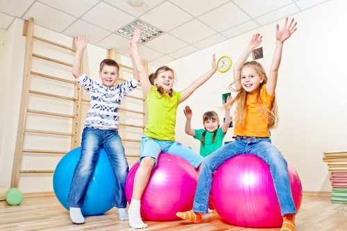 Children playing on yoga ball